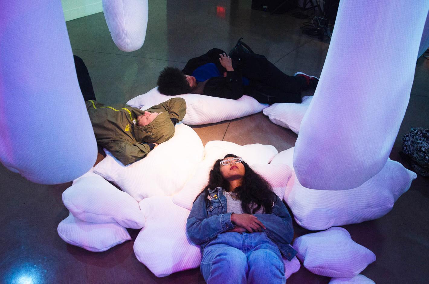Students lay on pillows part of an installation called “Serotonin” at the opening reception for Macro Waves’ NVM Gallery at SF State on Monday, October 19, 2017. (Richard Lomibao/Golden Gate Xpress)