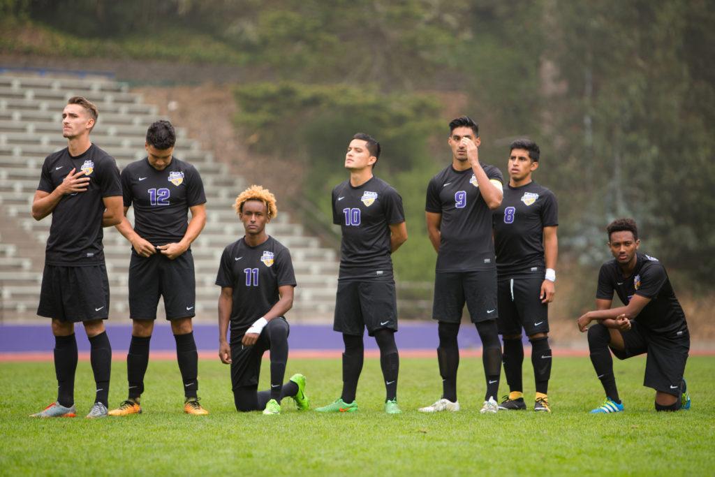 Members of the SF State Mens soccer team kneel during the National Anthem. (Golden Gate Xpress/Mitchell Mylius)