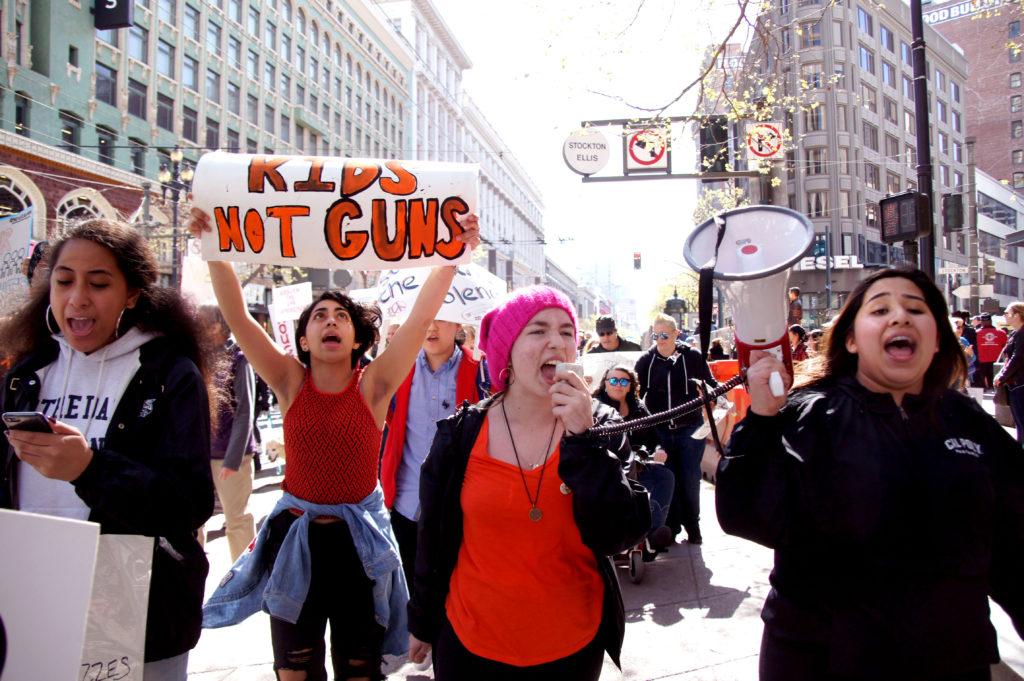 Norte Dame Belmont High School Students Feauint Saulala, left, Gia Elhihi, second left, Lucie Nash, second right, and Andrea Rios, left, leads crowd to march against gun control in San Francisco on Saturday, March 24, 2018.  (Aya Yoshida / Golden Gate Xpress)