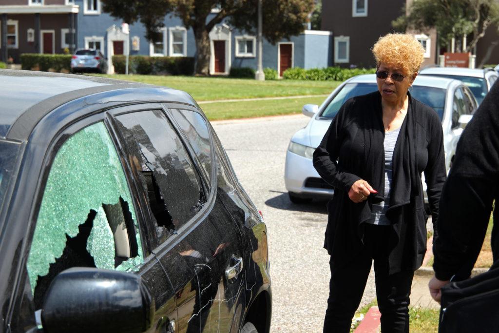 Hazel Jackson, a Parkmerced resident, inspects her vandalized car at Juan Bautista Circle near Fuente Avenue in the Parkmerced neighborhood close to SF State on Wednesday, May 16, 2018. The act of destruction seems to be racially motivated.  (Christian Urrutia/ Golden Gate Xpress)