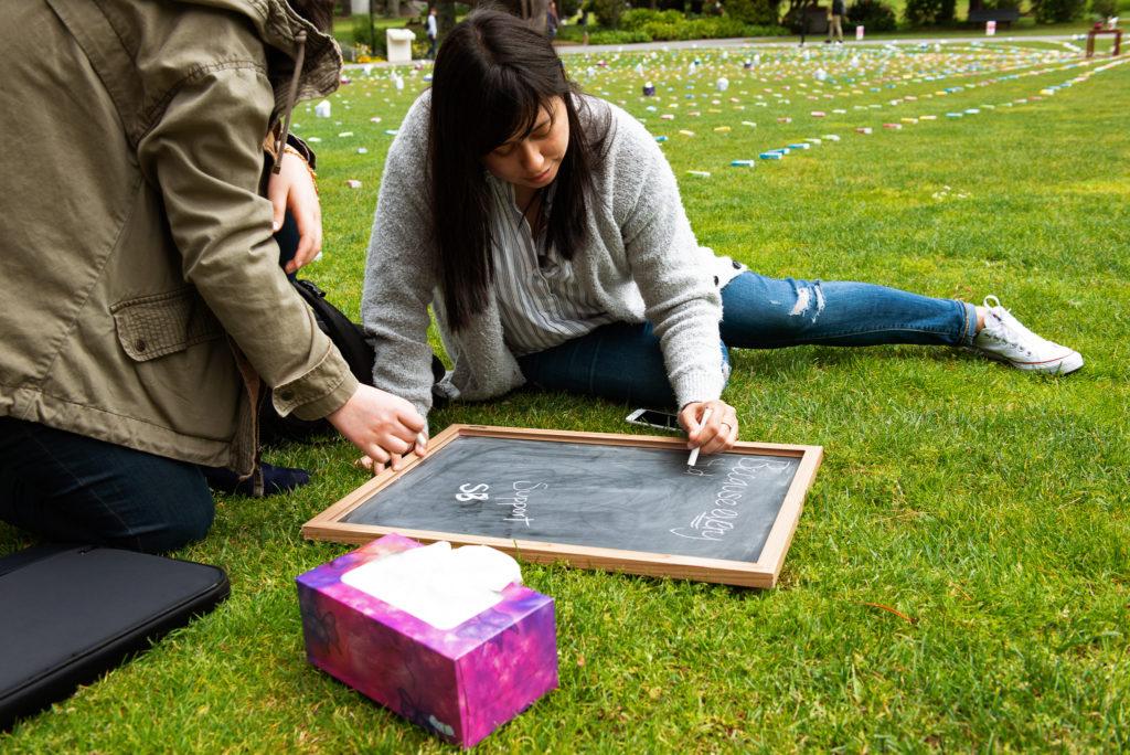 Mariana Verdin, a graduate counseling student, sits down with her classmate to take part of the Tissue for Issues visual display at SF State on Wednesday, May 9, 2018. (David Rodriguez/Golden Gate Xpress)