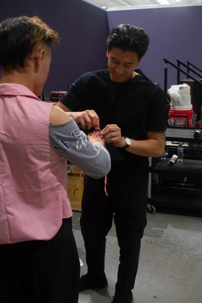 Kameron Santos dresses his model, Alex Banh before the dress rehearsal for Runway 2018: Diverge on Thursday, May 10 2018.