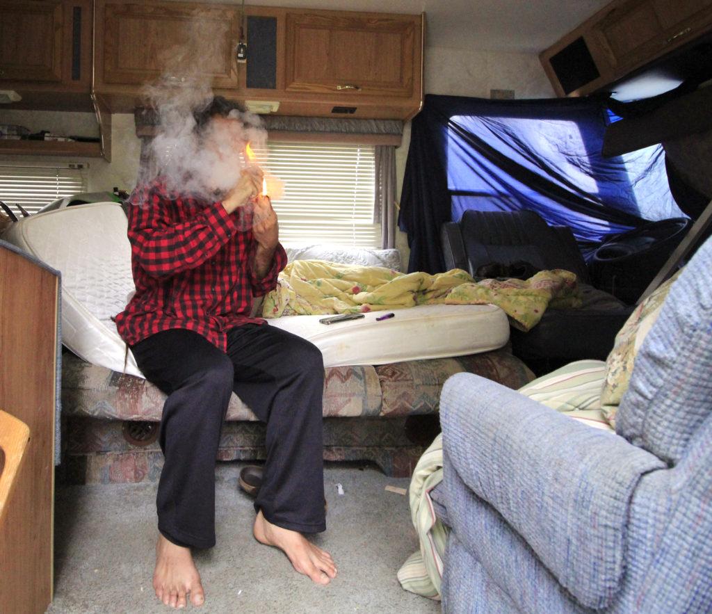 Juan Martinez, who moved to San Francisco from Brazil, smokes cannabis inside his motorhome parked on Lake Merced Boulevard on Monday, Sept. 3. Martinez is one of many who are living out of their vehicles, either by choice or who are forced to, because of the lack of affordable housing in the Bay Area. (Lindsey Moore/Golden Gate Xpress)