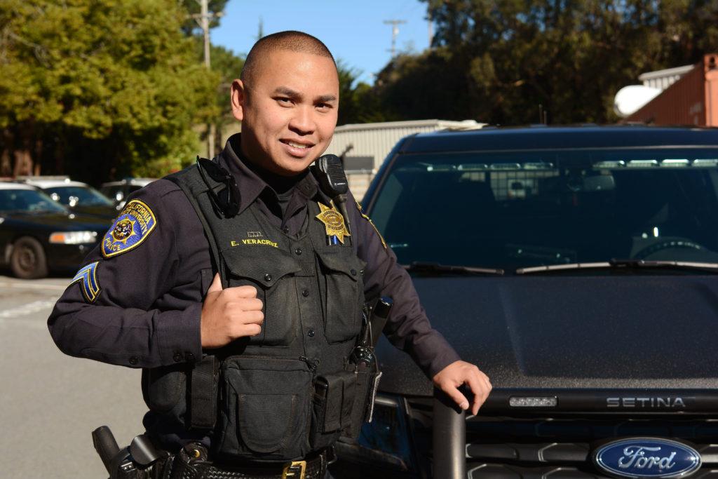 Cpl. Enrique Veracruz rests his hand on a squad car by the University Police Department station at SF State in San Francisco, Calif., on Thursday, Dec. 6, 2018. Veracruz is a six-year veteran of the SF States police force. (Aaron Levy-Wolins/Golden Gate Xpress)