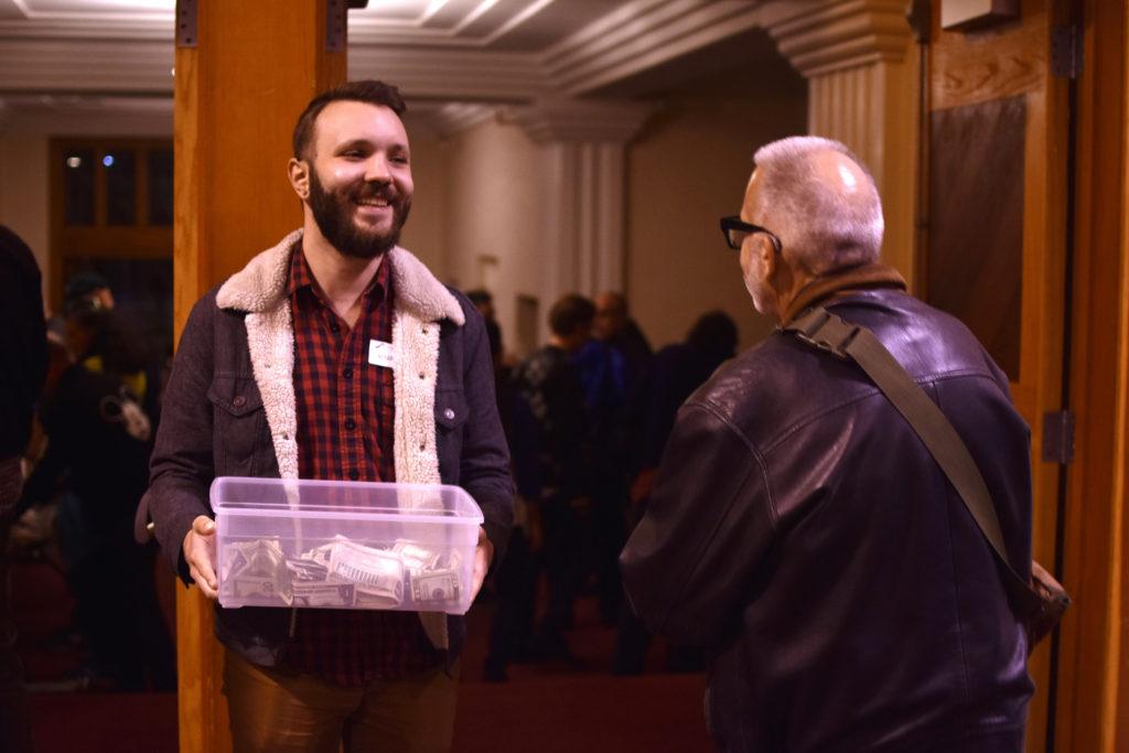 Mike Mykolaichuk collects money in a donation box as guests leave the benefit concert to fund Campfire disaster relief for Paradise at Bahá’í Center of San Francisco on Sunday, Jan. 27.