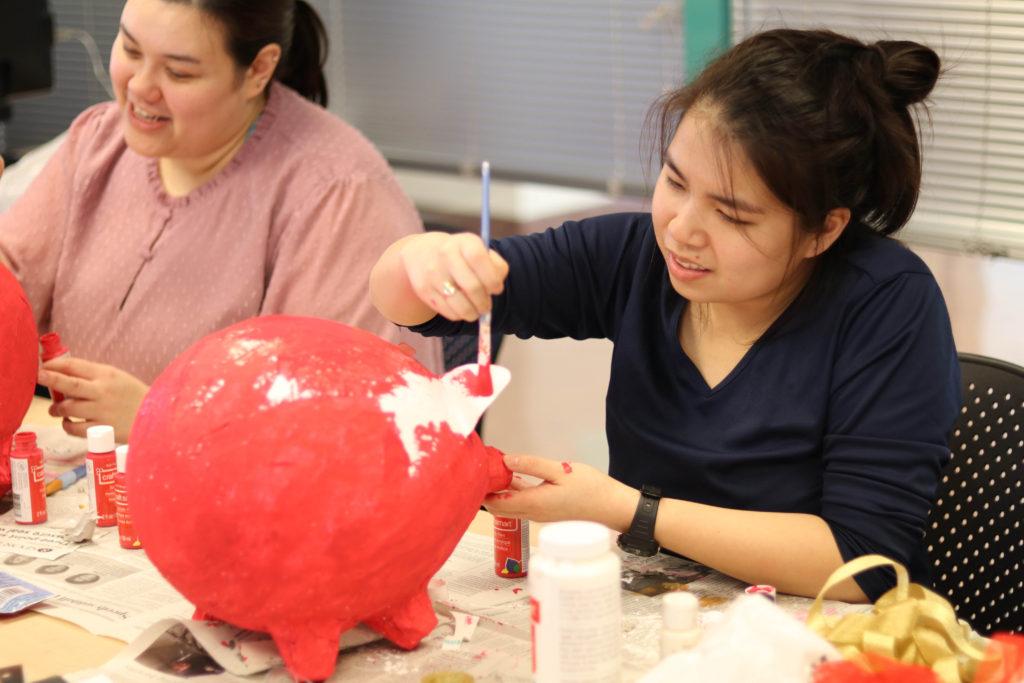 Mei Kelly, a Chinese flagship major, paints a papier-mache pig thats being used as a table center piece for the Chinese New Year Celebration in the humanities building on Feb. 20, 2019.