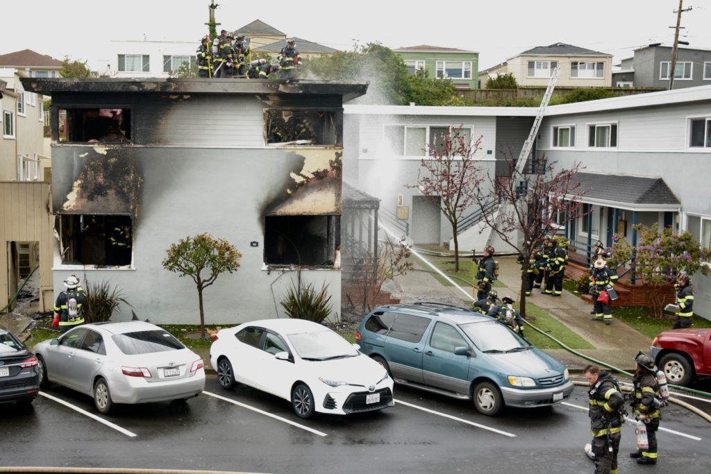 Firefighters check for hotspots on top of the burned apartment building at 88 Crestwood Drive in Daly City, Calif. on Tuesday, March 5, 2019. Photo by Tristen Rowean.