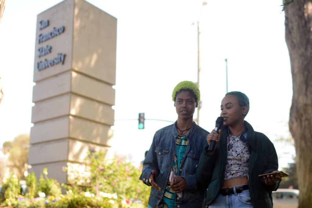 Isis (left), 22, an Africana studies major looks on as Ola (right), 22, an psychology major and Africana studies minor, reads a prepared statement after protesting the CSU settling a lawsuit regarding anti-Zionism by blocking Muni tracks at 19th and Holloway Avenues on Thursday, Mar. 21, 2019. (AARON LEVY-WOLINS/ Special to Golden Gate Xpress.)