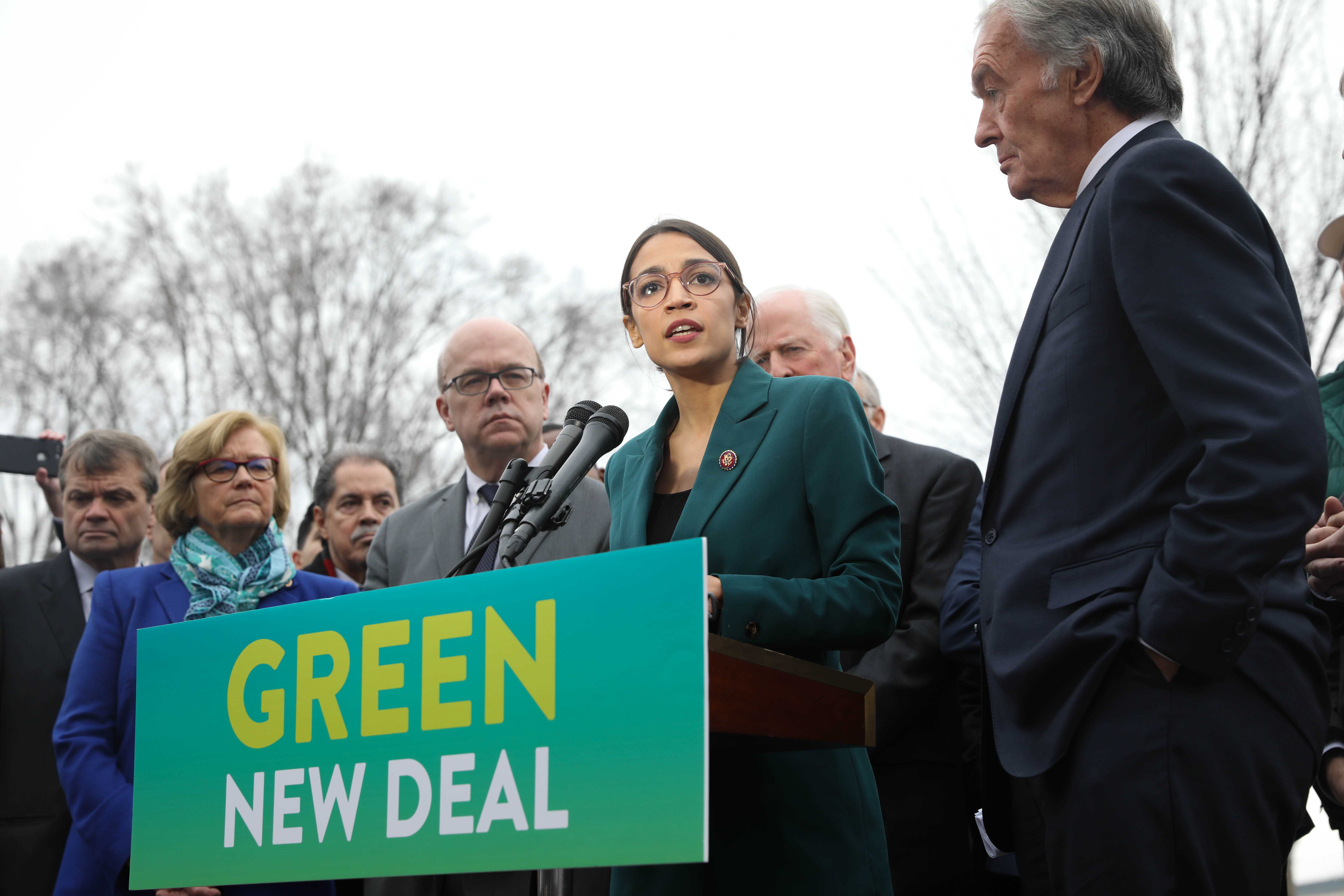 Representative Alexandria Ocasio-Cortez (center) speaks on the Green New Deal with Senator Ed Markey (right) in front of the Capitol Building in February 2019. (Photo by Senate Democrats via Wikimedia Commons.)