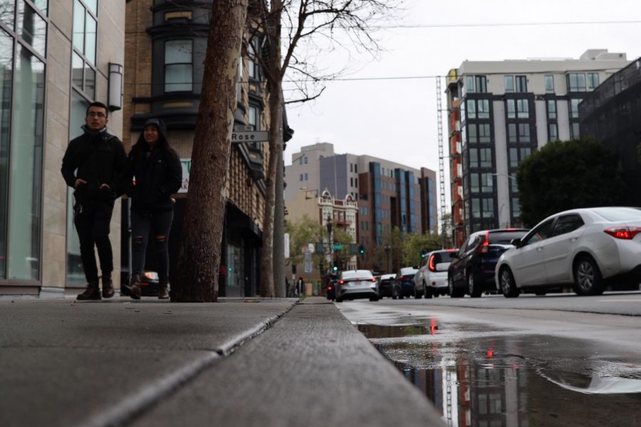 People walk on the sidewalk  towards a cat cafe  on a rainy day in Sam Francisco on Saturday March 14, 2020. (Emily Curiel / Golden Gate Xpress