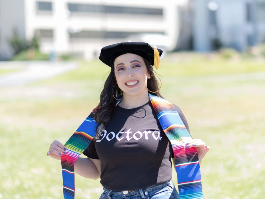 Norma R. Salcedo in her cap and sarape style sash on the lawn across the J. Paul Leonard Library celebrating her Ed.D. in Educational Leadership from the Graduate College of Education (GCOE) at San Francisco State University.