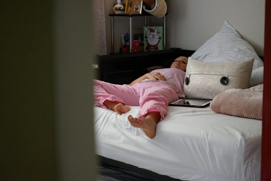 Lucy Da Silveira rests on her bed after a long shift working at Kaiser Permanente, in San Jose, California. (Daniel Da Silveira / Golden Gate Xpress)