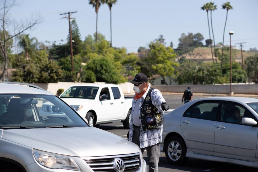 The Sabbath Keepers guide cars through the parking lot to the food drive. Photographed in Riverside, California. (Maddison October / Golden Gate Xpress)