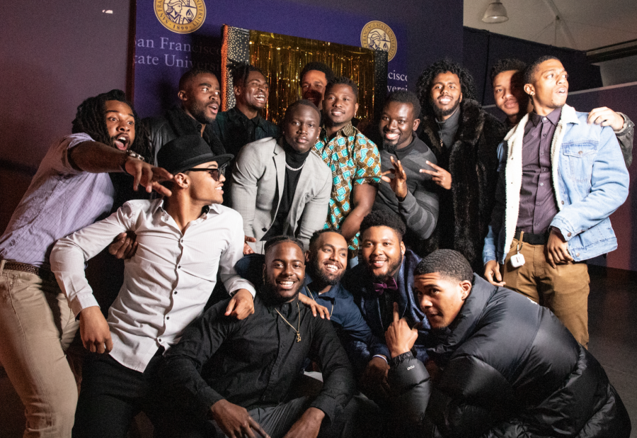 A group gathers in front of the photo booth to take a photo at the Black Mens Appreciation
event in the Annex on February 27, 2020.