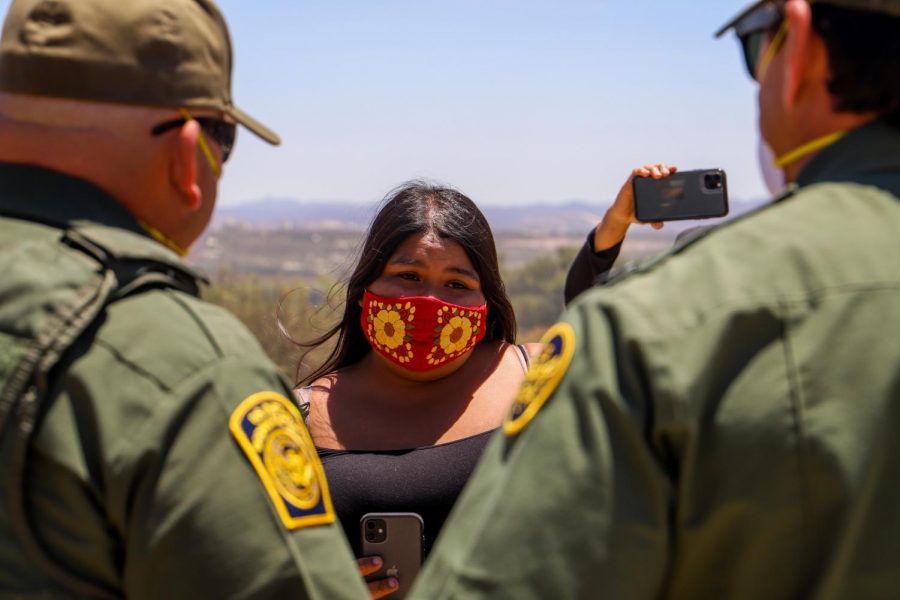 Cynthia Parada, a council woman of the La Posta band of the Kumeyaay tribe, explains to border patrol why it would be disrespectful to break up the group amidst their prayer. The protestors have taken to filming the action of USBP all day long, and at every interaction, to share on their social media sites and to ensure accountability. (Camille Cohen/ Golden Gate Xpress)