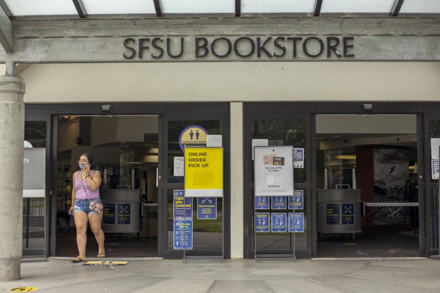 A student wearing a face covering walks out of the SF State bookstore on the first day of remote learning.