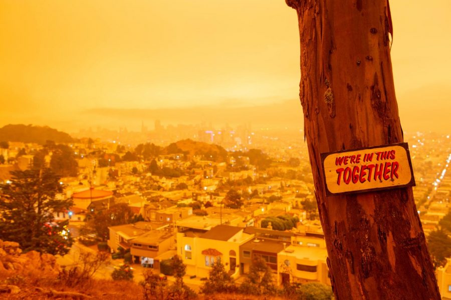 A sign with the words “We’re in this together” stands in front of an orange covered city view from Tank Hill in San Francisco, CA., Sept. 9, 2020 (Sean Reyes / Golden Gate Xpress)