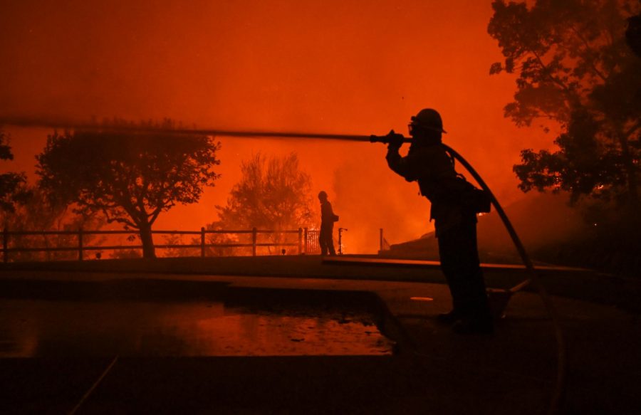 Firefighters spray water on a house located on Vaughn st in East Santa Rosa, California early Monday morning. (James Wyatt / Xpress Media)