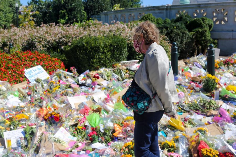 An older woman looks toward the display of gifts and goods in memory of Ginsburg. (Olivia Wynkoop / Xpress Media)