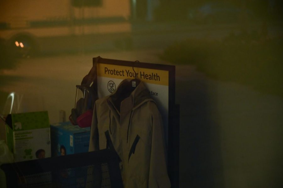Hazmat suit and an air purifying respirator are seen through the window of the J. Paul Leonard Library. (Dyanna Calvario/ Golden Gate Xpress / San Francisco, CA., Aug. 25, 2020)