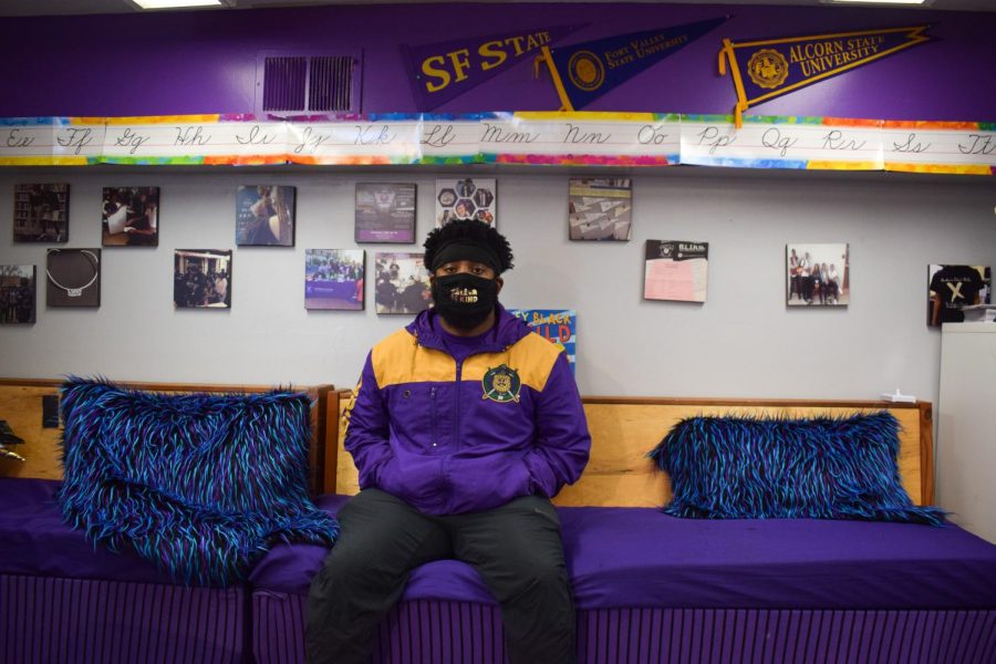 Jason Phillips, SF State alum and vice president of Omega Psi Phi Fraternity Inc., Pi Chi Chapter, sits in a space for youth where he works at 100% College Prep. (Lucky Whitburn-Thomas / Golden Gate Xpress)