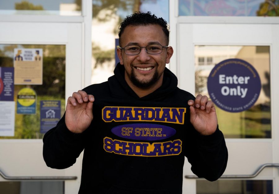Joel Jerimiah Martin-Dill shows off his Guardian Scholars sweatshirt in front of the Student Services Building at SF State on May 4, 2021. The Guardian Scholars program started in 2005 to help any current or former foster care youth with their college experience. (Samantha Laurey / Golden Gate Xpress)