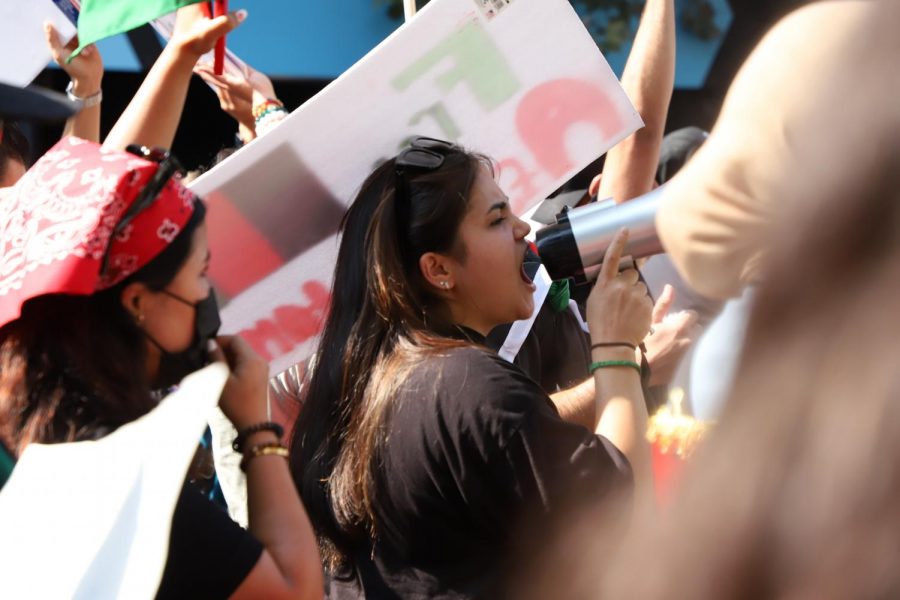 A protest organizer leads chants with a megaphone as the group moves down Market Street on Aug. 28, 2021. Group organizers stuck to their guidelines and maintained a peaceful gathering. (Amaya Edwards / Golden Gate Xpress) 