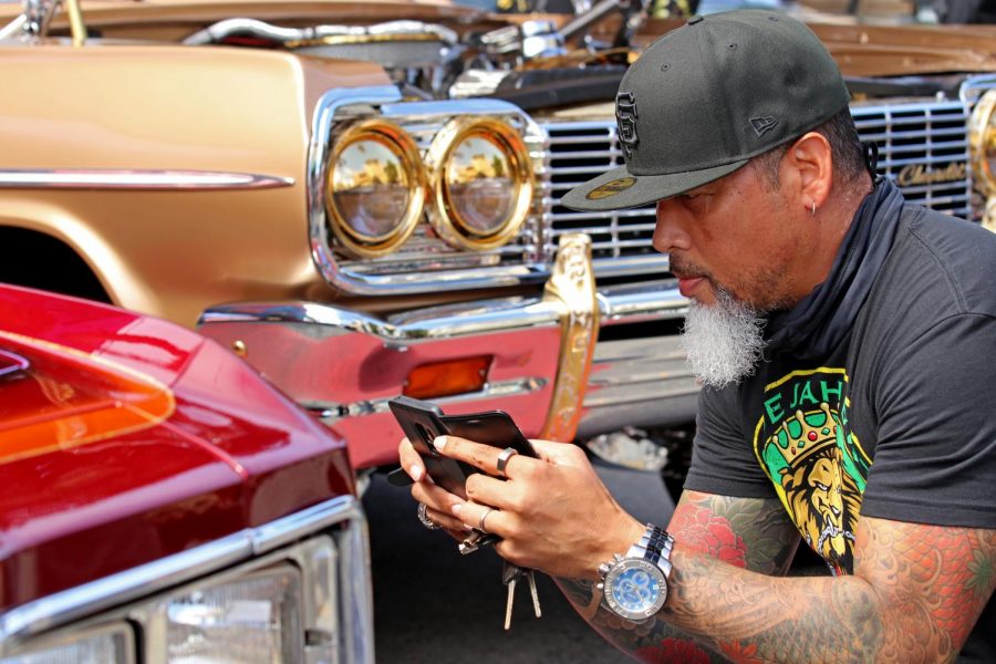 Ronald Holmes, a former Mission District resident, takes a photo of a lowrider car during the lowrider council celebration and cruise. Holmes came to support the community and explore the event. (Sabita Shrestha/Golden Gate Xpress)