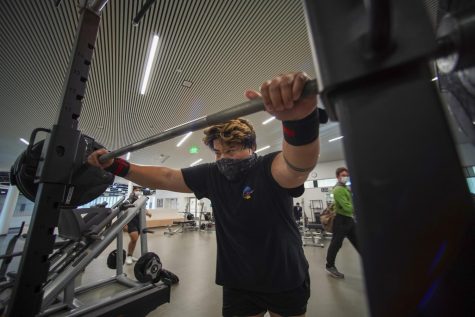 Roger Ryan lifts a set of dumbbells inside the weight training area of the Mashouf Wellness Center at SF State on Sep. 14, 2021. (Nicolas Cholula / Golden Gate Xpress)

