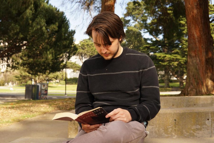 SF State student Trevor LeMay reads a book near Cesar Chavez Student Center. SF State begins spring semester classes virtually for the first three weeks due to the omicron surge. (Maximo Vazquez / Golden Gate Xpress)