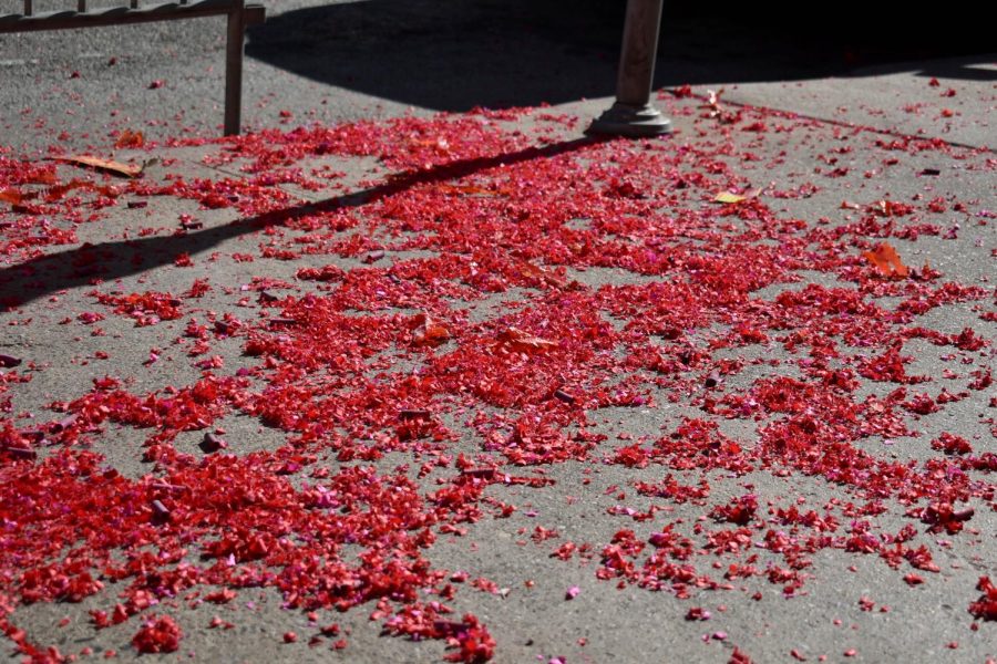 Red firecracker paper litters the corner of Clay Street and Grant Avenue in Chinatown on Feb. 1, 2022. (Karina Patel / Golden Gate Xpress)