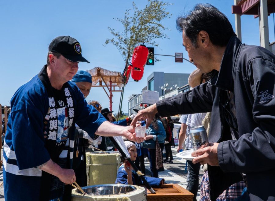 Festival participants hand out free Sake to attendees on Post Street in Japantown on April 17. (Rashik Adhikari)