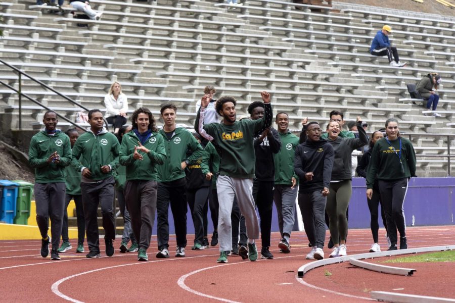 Athletes from Cal Poly Pomona cheer for their fellow team member, who is competing in the high jump, during their warm-up lap around the track before competing during the California Collegiate Athletic Association track invitational on May 5. (Trista Livermore for Golden Gate Xpress)