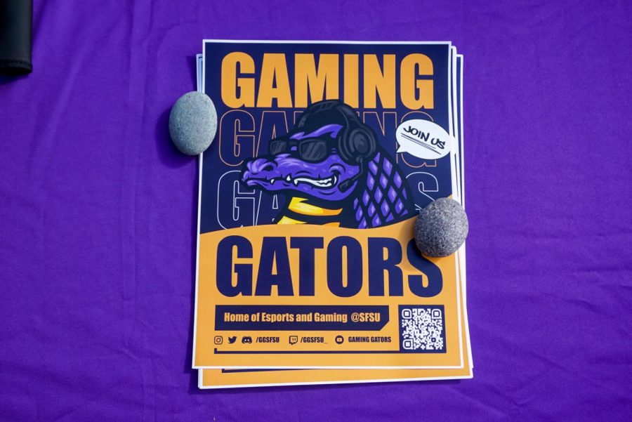 Fliers that read “Gaming Gators” are stacked on SF State’s Gaming Gators table in front of the Cesar Chavez Student Center during Welcome Week on Aug. 30. The club is spreading the word about the gaming club and new video game minor being offered on campus. (Tatyana Ekmekjian / Golden Gate Xpress)