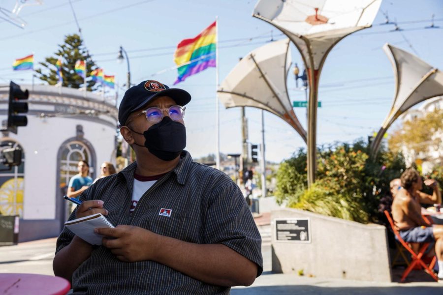 Jared Luansing writes a piece of poetry in the Castro District on Oct. 7, 2022. Luansing is enrolled in the Writing on Muni course in SF State’s Experimental College, where students go on different field trips in the city to write poems. (Juliana Yamada / Golden Gate Xpress)