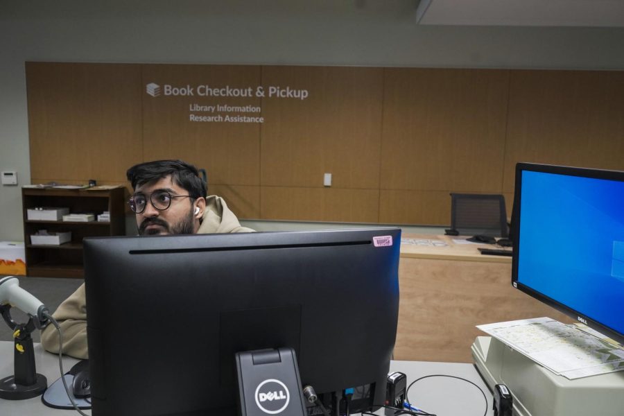 DIvy Ramani, Junior, talks with a student at the front desk of J. Paul Leonard Library at SF State in San Francisco CA., on Jan. 30, 2023. (David Jones / Golden Gate Xpress)