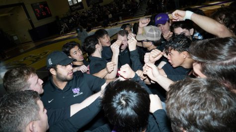 The SF State wrestling team joins in for a huddle before an at-home match in Dan Nasser plaza on January 29, 2023. The team chanted the name of Hamzah Alsaudi in a mixture of visible emotions and promised to take home a win in his honor. Alsaudi is still missing at sea after two weeks of searching. (Joshua Carter/Golden Gate Xpress)