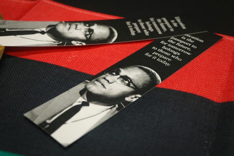 Bookmarks of Malcolm X rest on a table at the Chicken and Juice event at SF State’s Cesar Chavez Student Center on Friday, Feb. 23, 2023. The event, also known as Black Family Luncheon, was started in the 90’s by then Africana Studies Department Chair Dr. Wade Nobles and offers Black faculty, staff and students a place to network and connect with each other.  (Gina Castro / Golden Gate Xpress) 