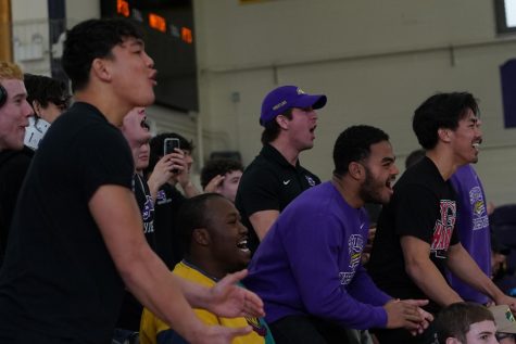 Members of SF State’s wrestling team celebrate as a teammate scores a hold on an opponent during a meet on January 28, 2023 (Joshua Carter / Golden Gate Xpress)