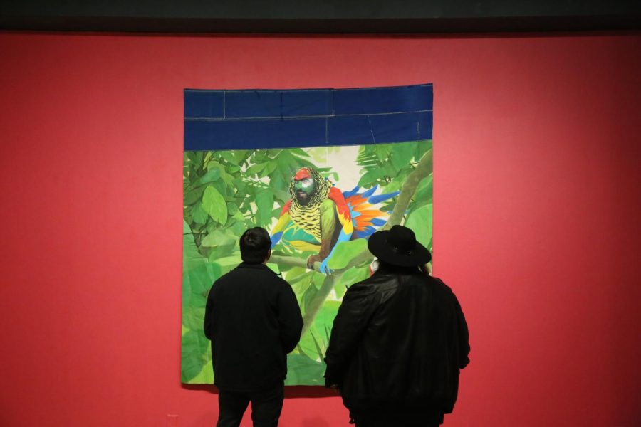 Gallery attendees admire Yaron Michael Hakim’s self-portrait “Self-Portrait as a Guacamaya Yellow-Sided Conure” in SFSU’s Fine Arts Gallery. (Eian Gil / Golden Gate Xpress)