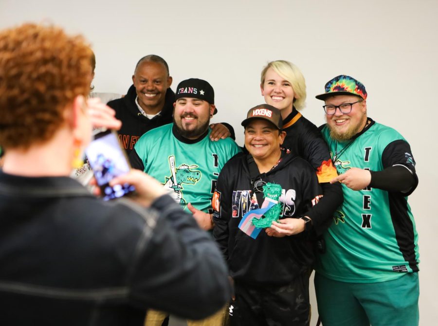 Chloe Simson (L) takes a picture of members of T-Rex San Francisco Bay Area Trans*, Queer and Friends Adult Softball Team at SF State’s Rosa Park Conference Center on Thursday, April 6, 2023. Tony Padia, one of the founders of the team, said he helped create the team to provide a non-gender specific space for people, specifically trans people, to play sports. (Gina Castro / Golden Gate Xpress)