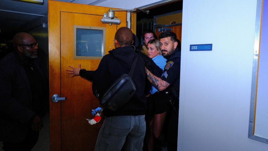 Campus police officers escort Riley Gaines out of Room 310 after Turning Point USA’s event featuring her as the speaker at SF State on Thursday, April 6, 2023. (Miguel Francesco Carrion / Golden Gate Xpress) 
