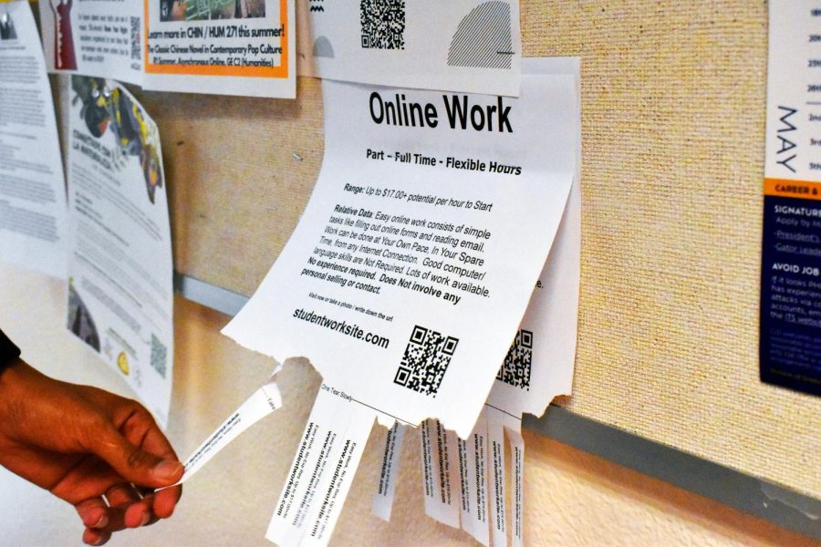 A photo illustration portraying a student taking a tab of a part time “online work” poster. These posters can be found around SF State’s campus. (Chris Myers / Golden Gate Xpress) 
