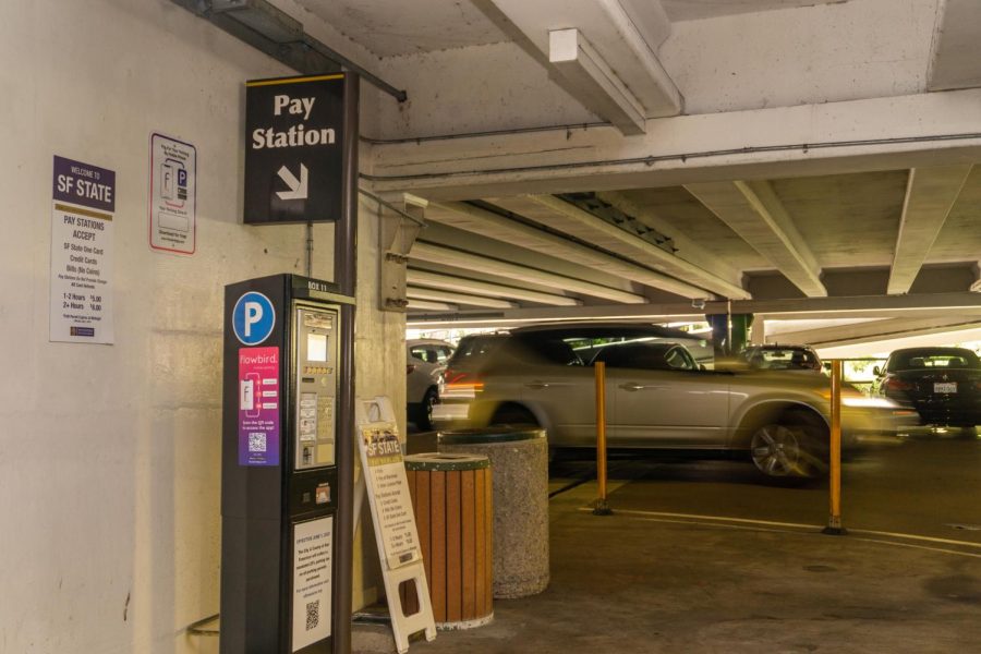 A car drives by a pay station in Lot 20 at SF State on May 8, 2023. (Dan Hernandez for Golden Gate Xpress)