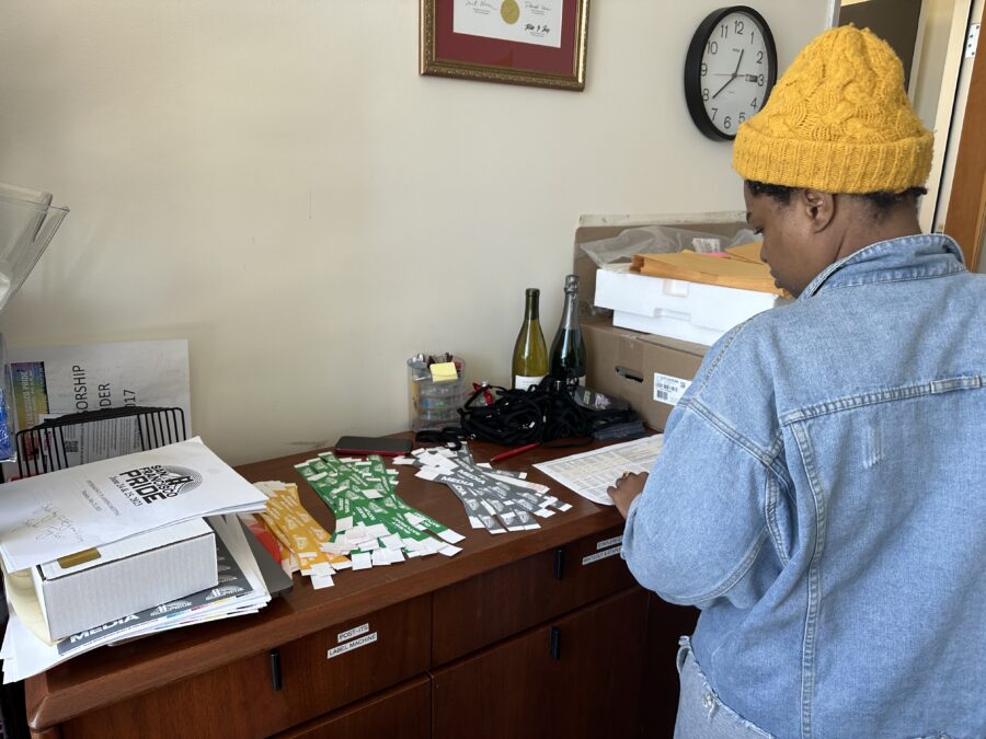 Melissa Dufort, program associate in the SF Pride committee, organizing the various access passes for upcoming pride social events on Mission St. on June 21, 2023. (Sydni Taylor / Golden Gate Xpress)