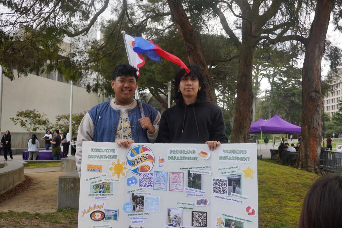 Left to right: Liam De Vera, 19, a pre-nursing student from Walnut Creek, Calif. and Christian Tamayo, 19, a kinesiology student from Pleasanton, Calif. Pose for a photo at the Pilipinx American Collegiate Endeavor (PACE) table during Club Rush near Malcolm X Plaza at SF State on Monday, August 21, 2023. (Neal Wong / Golden Gate Xpress)