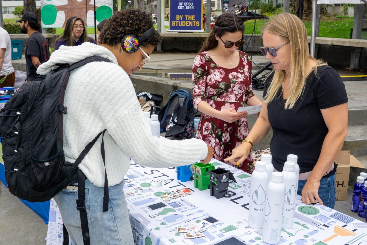 Student Aloe Bell plays a game of sorting out waste materials during the Open House event held at Malcolm X Plaza on Sept. 26, 2023. (Ryosuke Kojima/ Golden Gate Xpress)
