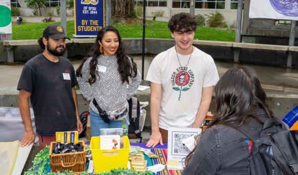 Brittany Hernandez, student director of the Environmental Resource Center, and her fellow staff talk with a student about environmental issues at the Open House event held at Malcolm X Plaza on campus in San Francisco, Calif. on Sept. 26, 2023. (Ryosuke Kojima/ Golden Gate Xpress)
