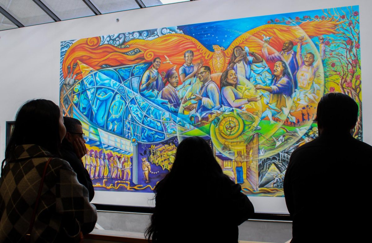 Attendees look at the mural while Yazmin Madriz tells them the deeper meaning that the mural has, Oct. 13, 2023. (Samantha Morales/Golden Gate Xpress)
