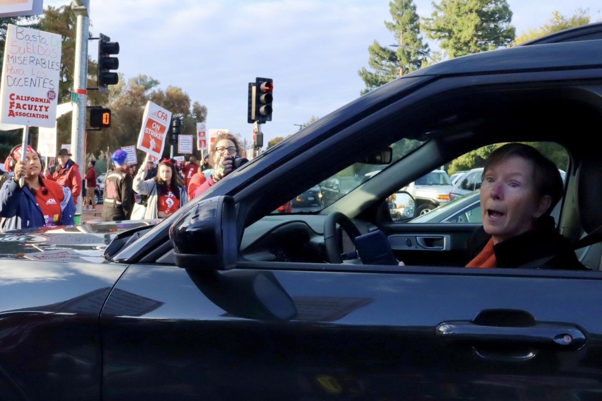 A woman in a car attempts to cross the picket line at Sacramento State University on Dec. 7, 2023. Picketers were attempting to block the intersection during the one-day CFA strike. (Adriana Hernandez/Golden Gate Xpress)